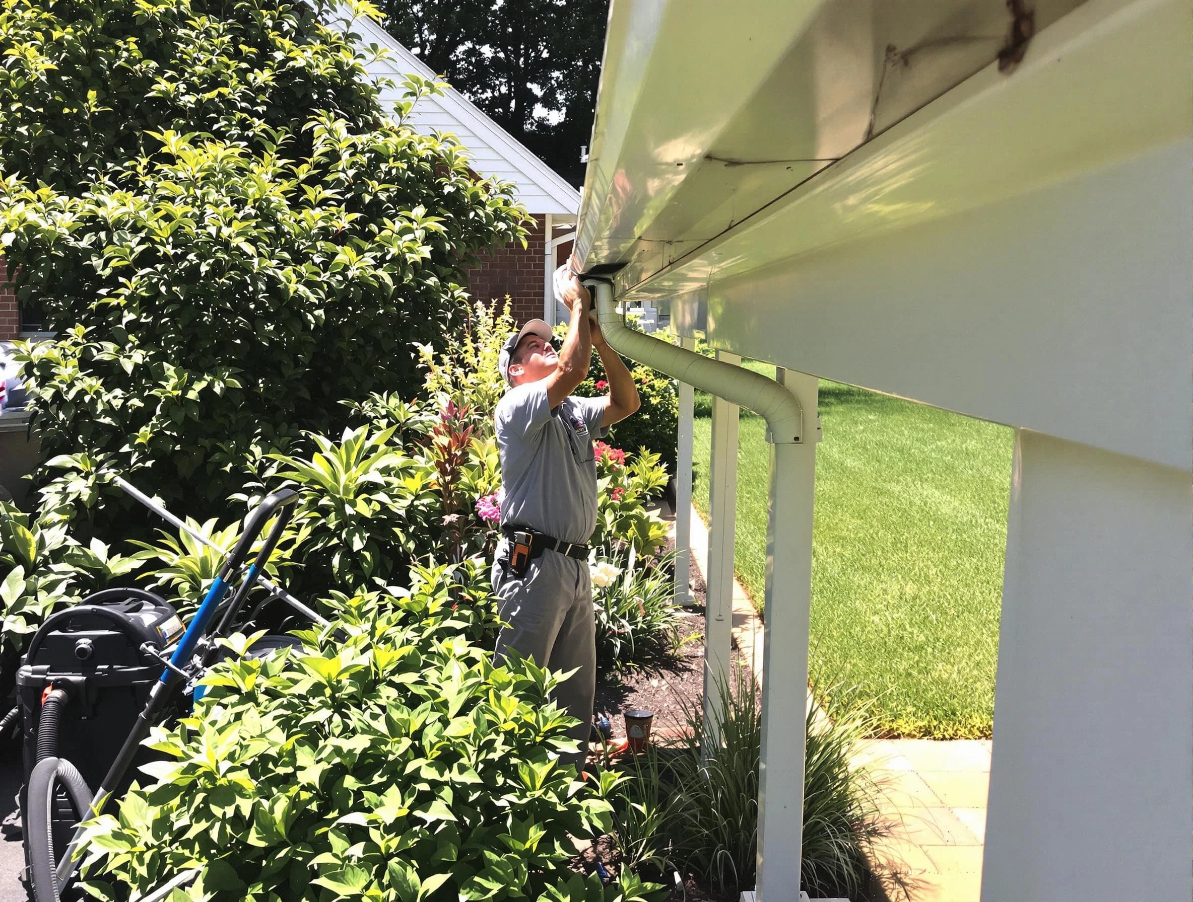 Technician flushing a blockage from a downspout in Euclid, OH